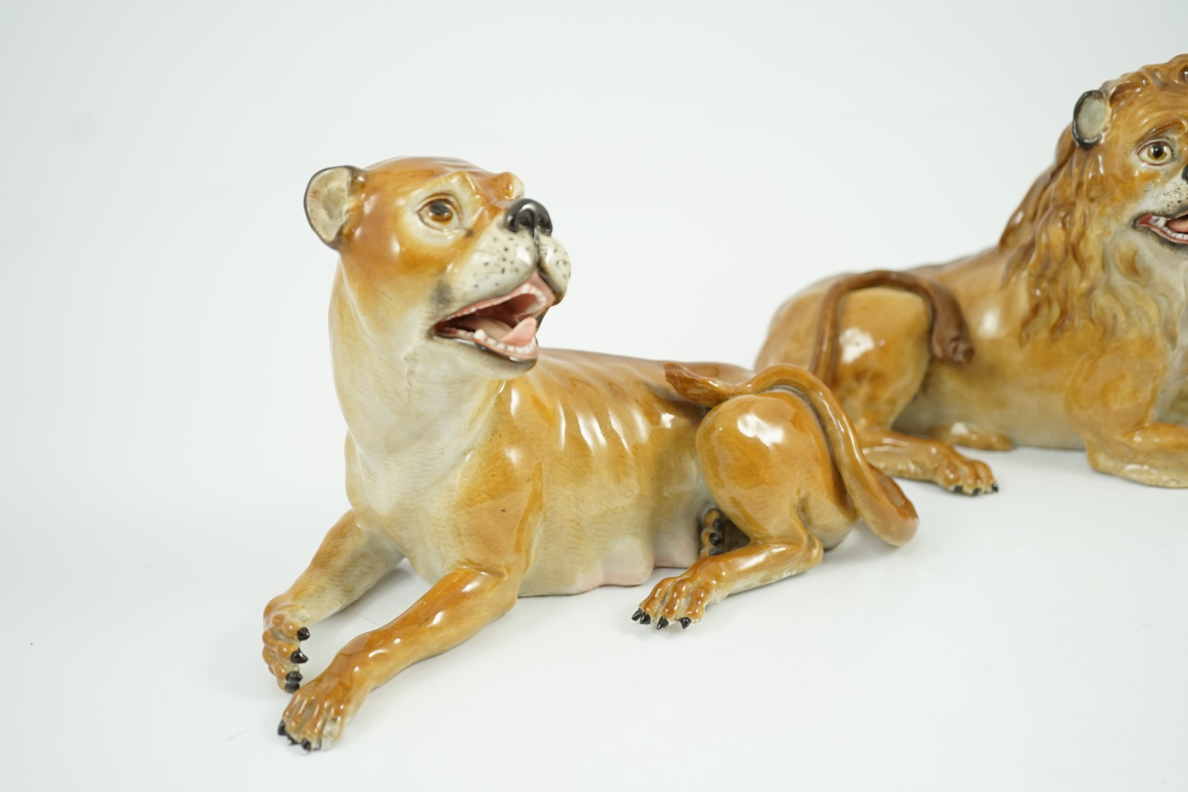 A pair of Meissen figures of a recumbent lion and lioness, 19th century, restoration